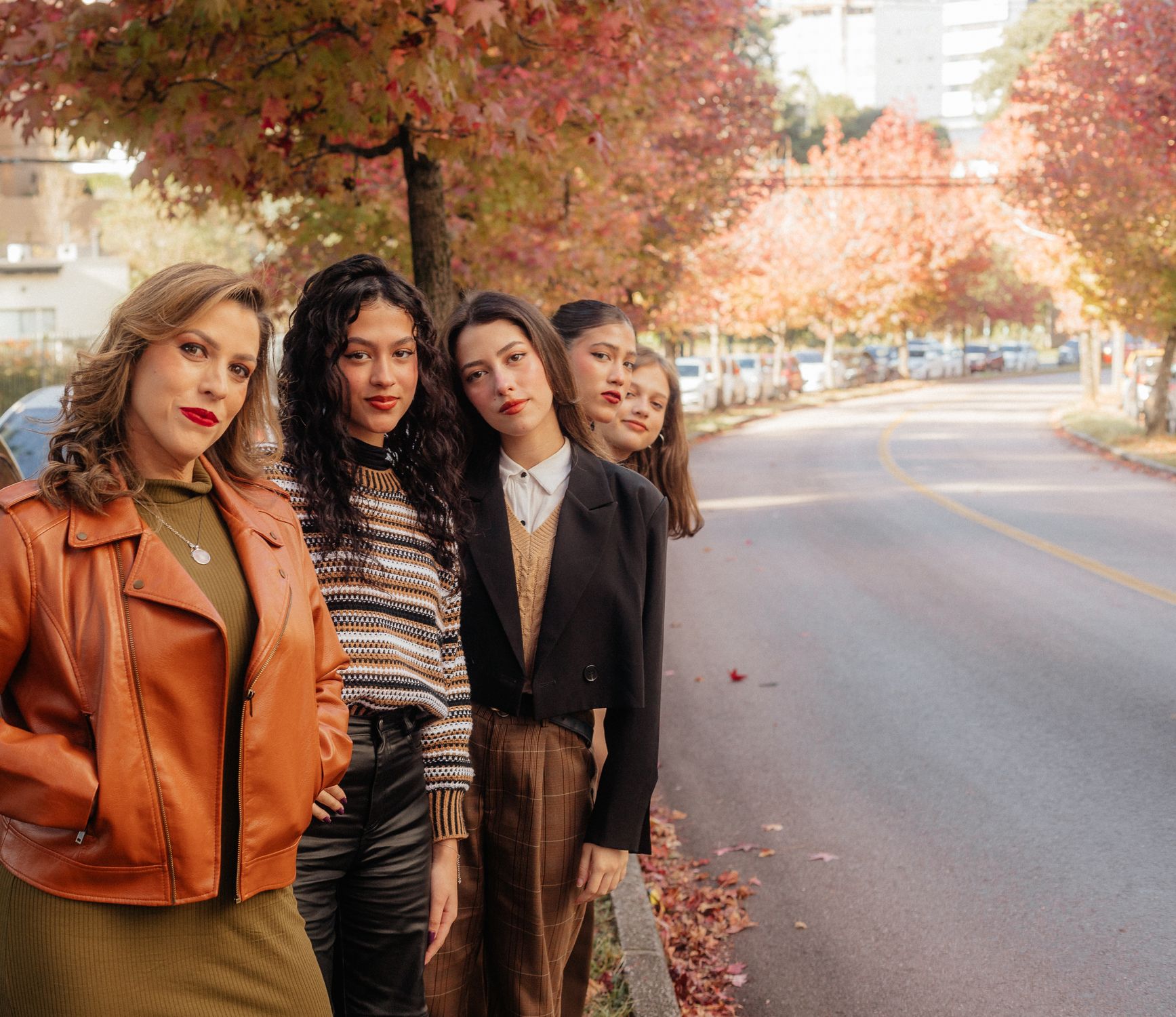 Group of women in autumn layers on a tree-lined street